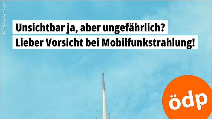 Die Spitze eines Mobilfunkmastes ragt in den blauen Himmel