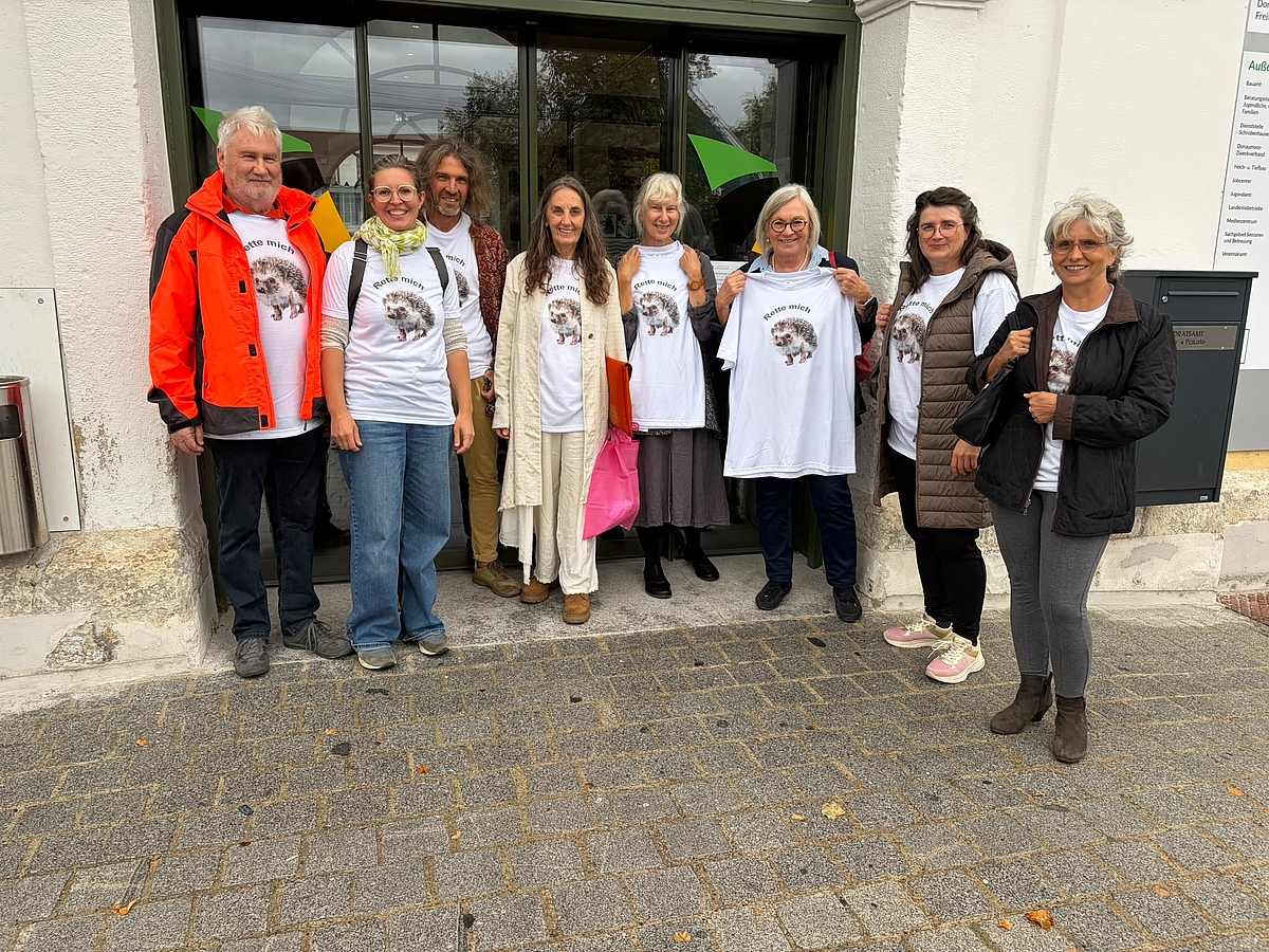 Acht Personen stehen vor dem Eingang des Landratsamtes. Alle tragen T-shirts mit dem Bild eines Igels und dem Aufdruck "Rettet mich"